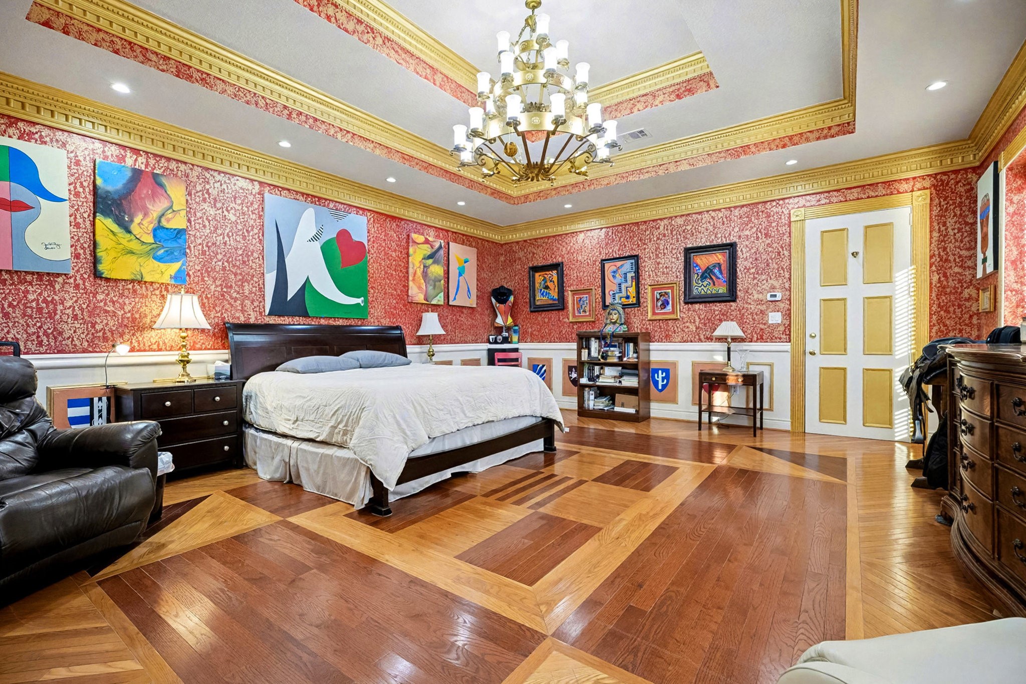 1200 Davenport Parkway Rosharon, TX 77583 - Photo 16 of 49 Spacious primary suite displaying bold red and gold design, statement chandelier, and
artistic wall décor.
