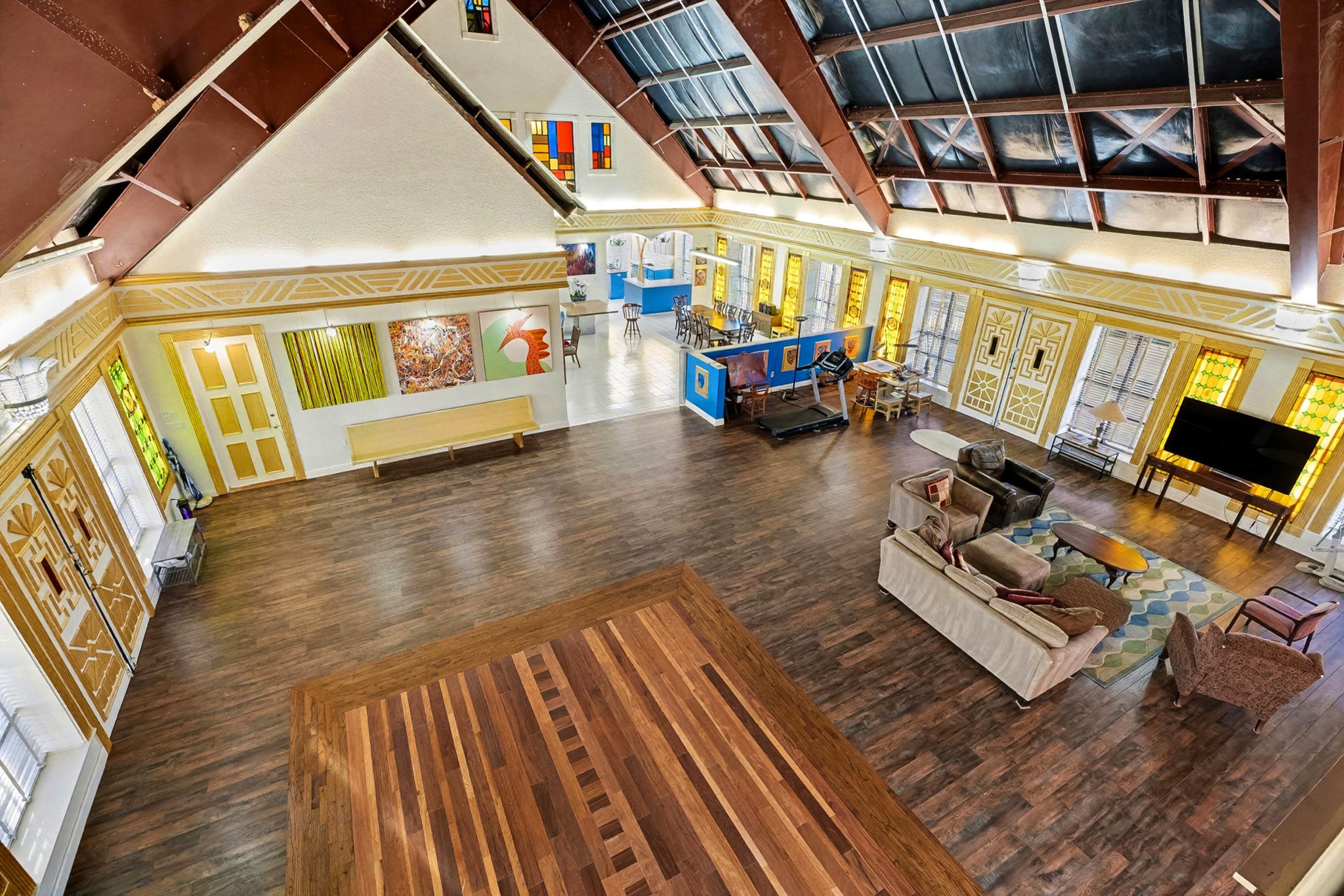 1200 Davenport Parkway Rosharon, TX 77583 - Photo 31 of 49 Second-floor (east end) loft view overlooking the expansive great room, highlighting custom inlaid
Brazilian oak flooring, stained-glass windows, and artistic architectural detailing
throughout the open-concept living space.