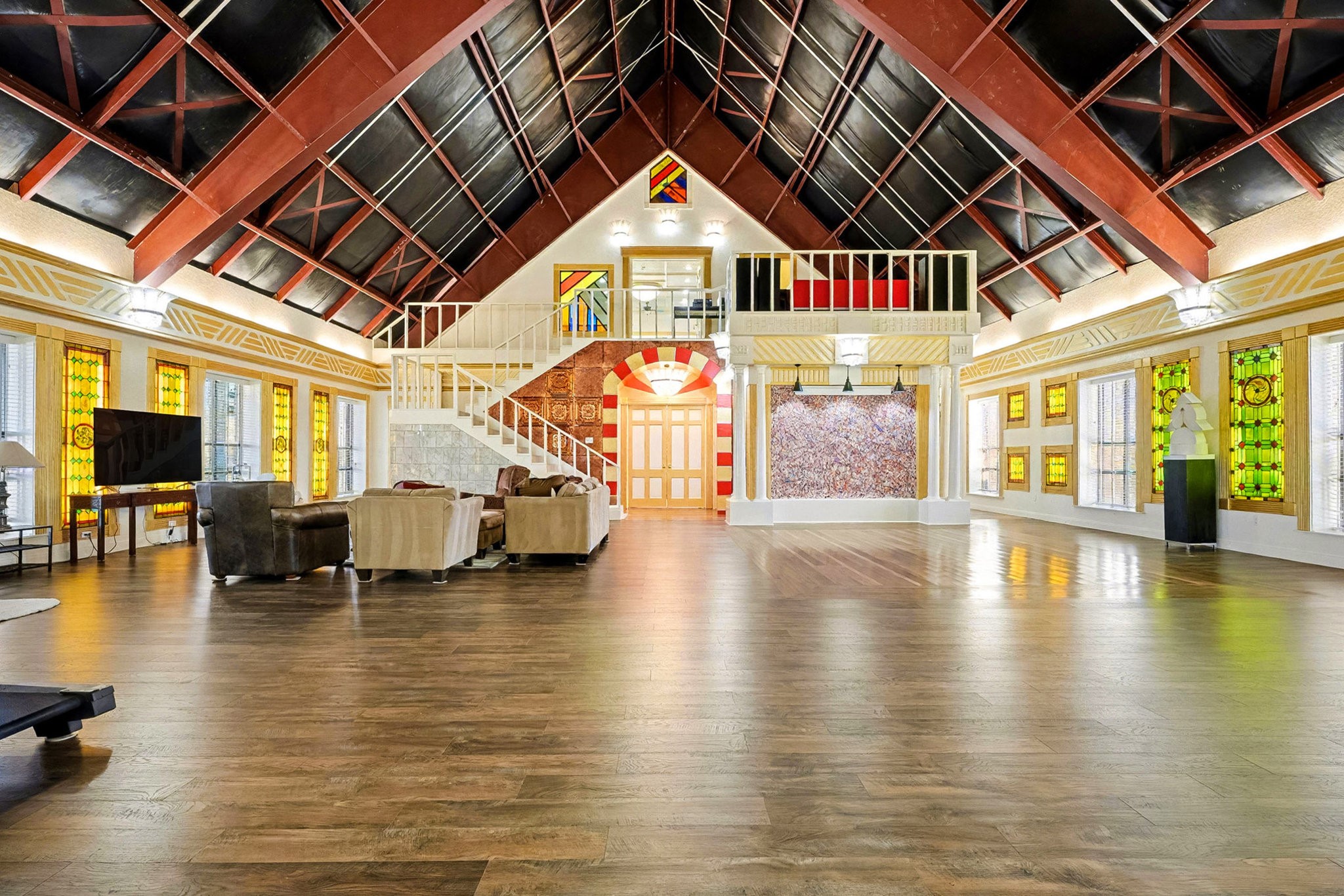 1200 Davenport Parkway Rosharon, TX 77583 - Photo 5 of 49 Lofted view of the grand staircase and spacious main living area, featuring vibrant
glasswork, custom finishes, and abundant room for creative living or multi-purpose use.