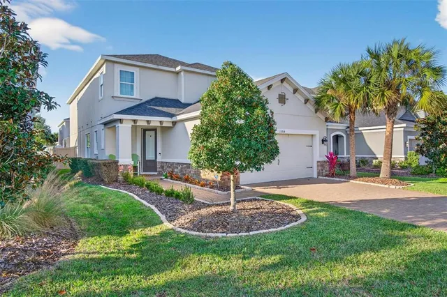 a front view of a house with a yard and trees