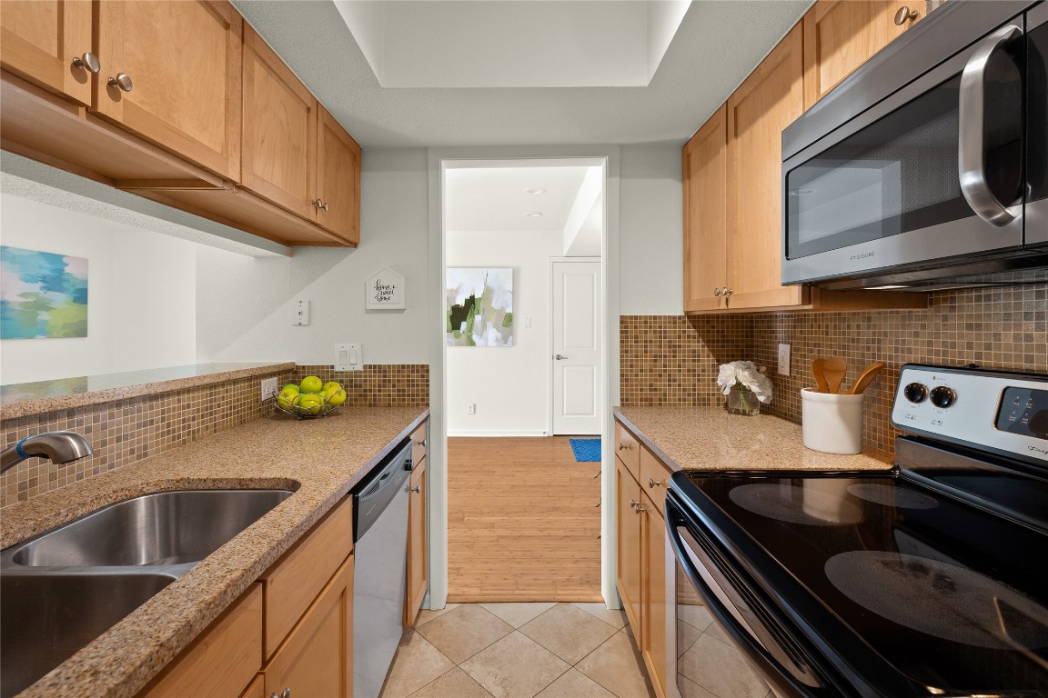 3204 Menchaca Road, Unit 216 Austin, TX 78704 - Photo 11 of 38 a kitchen with stainless steel appliances granite countertop a sink and a stove