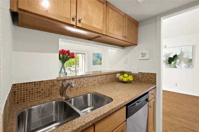 a kitchen with a sink and a stove with wooden floor