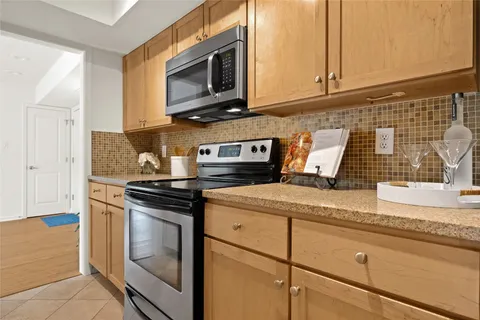 a kitchen with granite countertop cabinets stainless steel appliances and a counter space