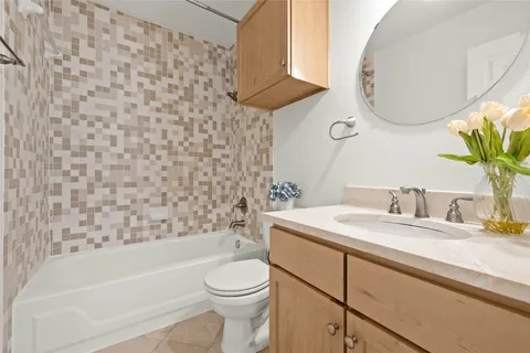 a bathroom with a granite countertop sink a toilet and bathtub