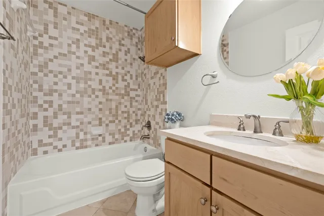 a bathroom with a granite countertop sink a toilet and bathtub
