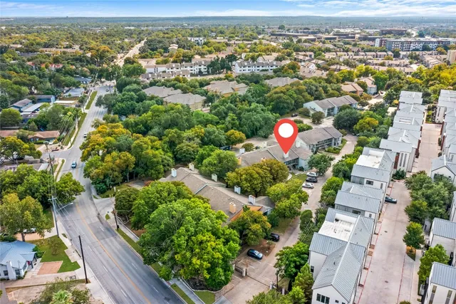 an aerial view of residential houses with outdoor space and street view