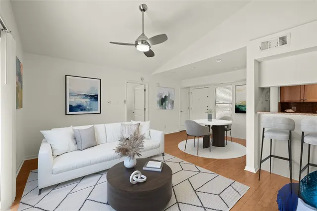 a living room with furniture and a dining table with kitchen view