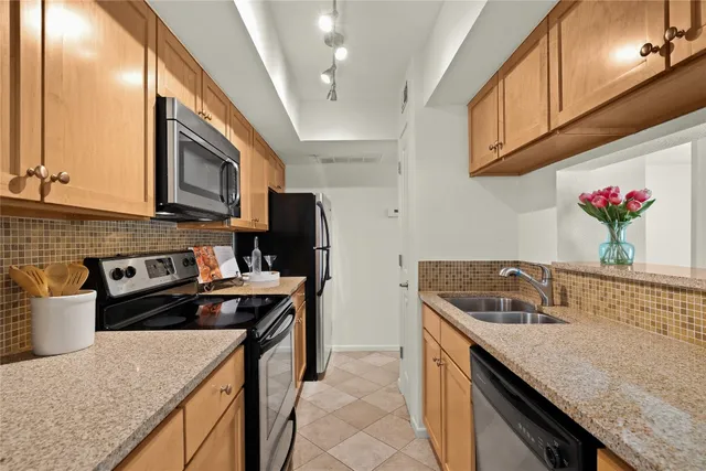 a kitchen with stainless steel appliances granite countertop a sink stove and refrigerator
