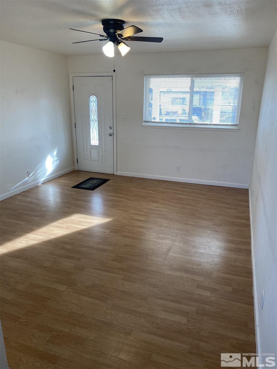 1165 Manhattan Street Reno, NV 89512 - Photo 2 of 14 an empty room with wooden floor fan and windows
