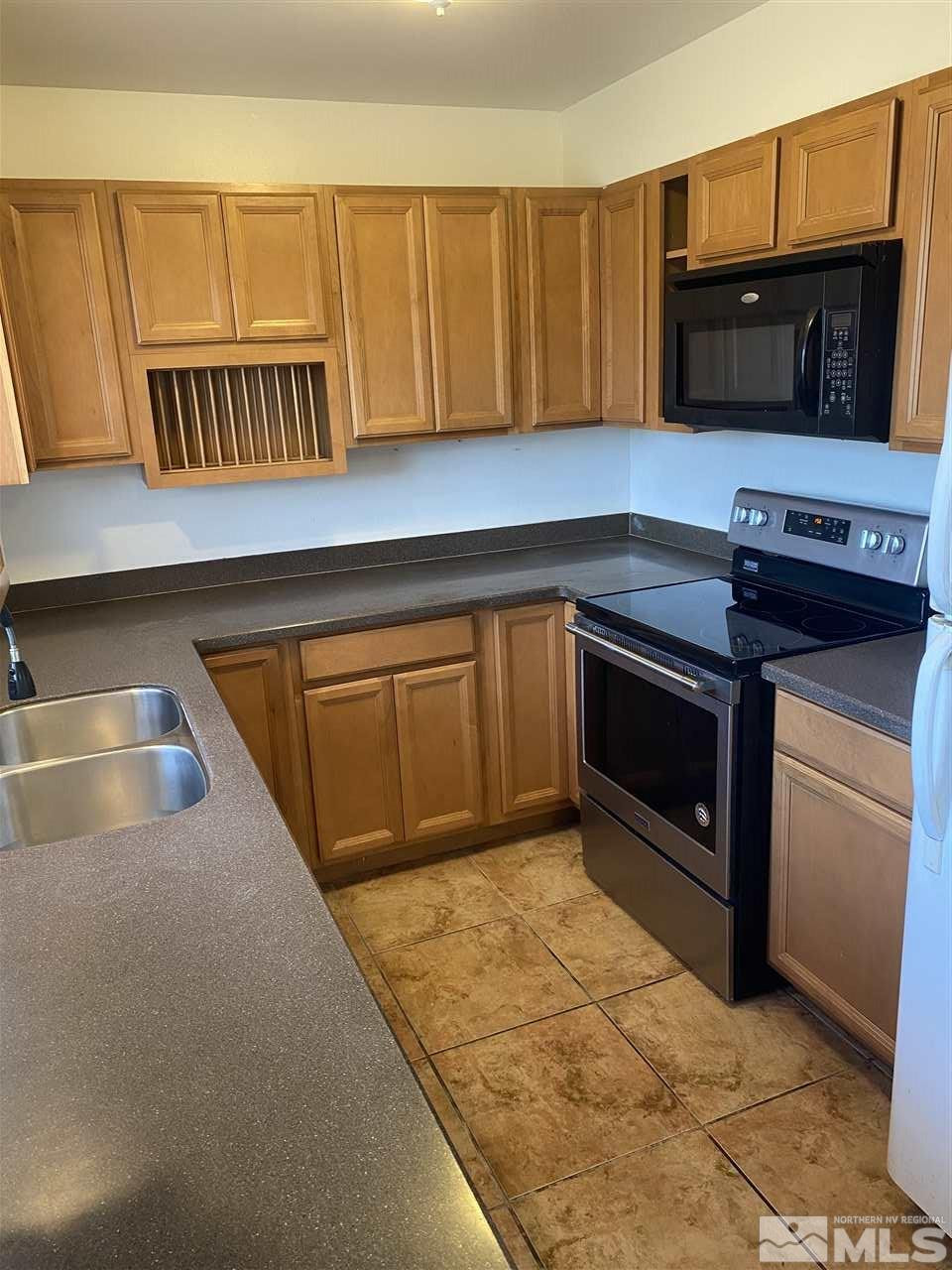 1165 Manhattan Street Reno, NV 89512 - Photo 4 of 14 a kitchen with wooden cabinets and a stove top oven