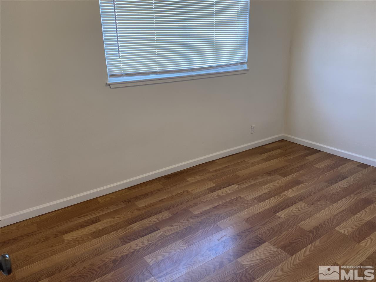 1165 Manhattan Street Reno, NV 89512 - Photo 9 of 14 an empty room with wooden floor and windows