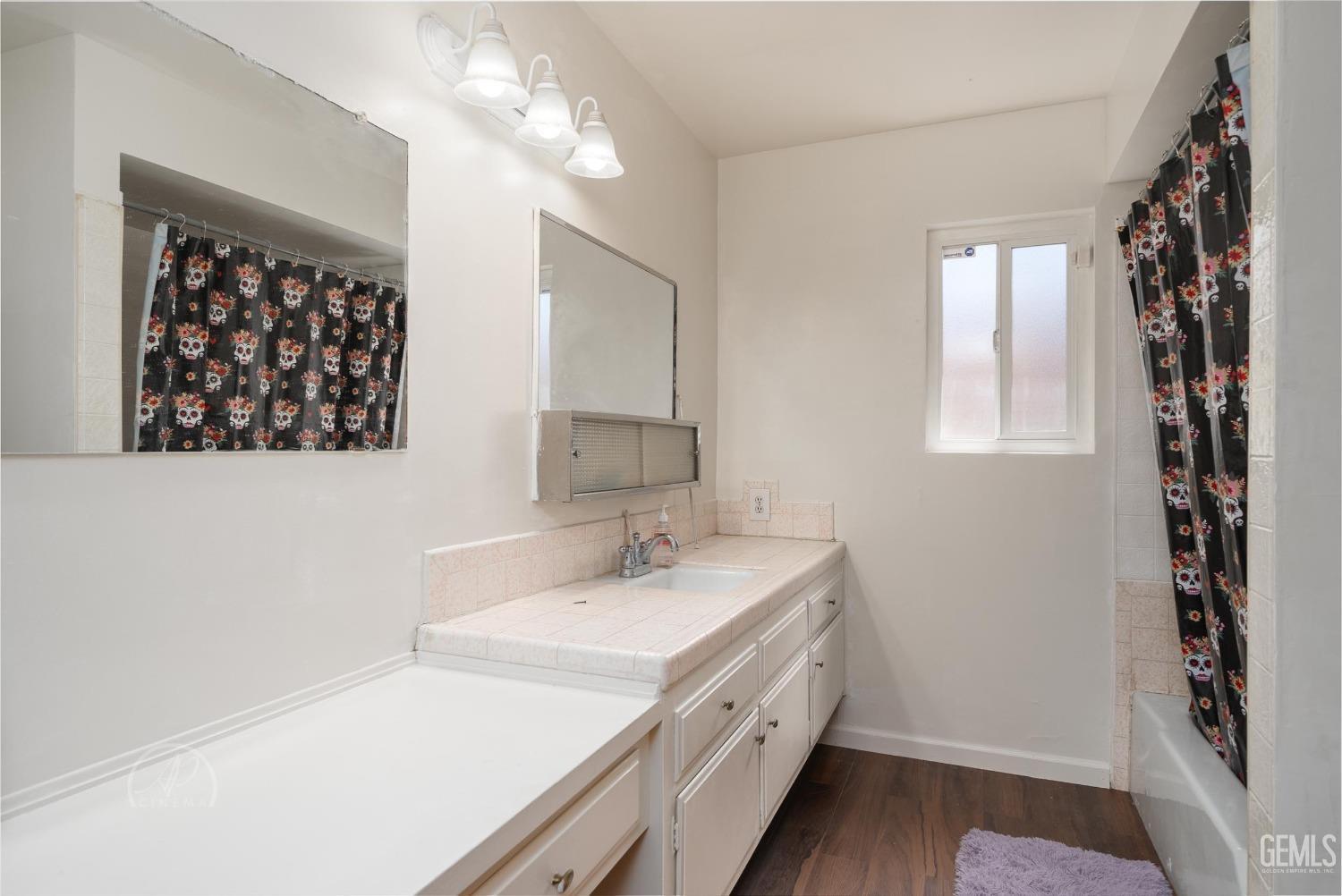Undisclosed Address Bakersfield, CA 93307 - Photo 11 of 26 a bathroom with a sink a vanity and a large mirror
