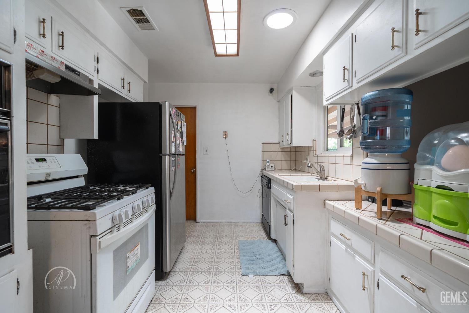 Undisclosed Address Bakersfield, CA 93307 - Photo 18 of 26 a kitchen with stainless steel appliances a refrigerator a stove and a sink