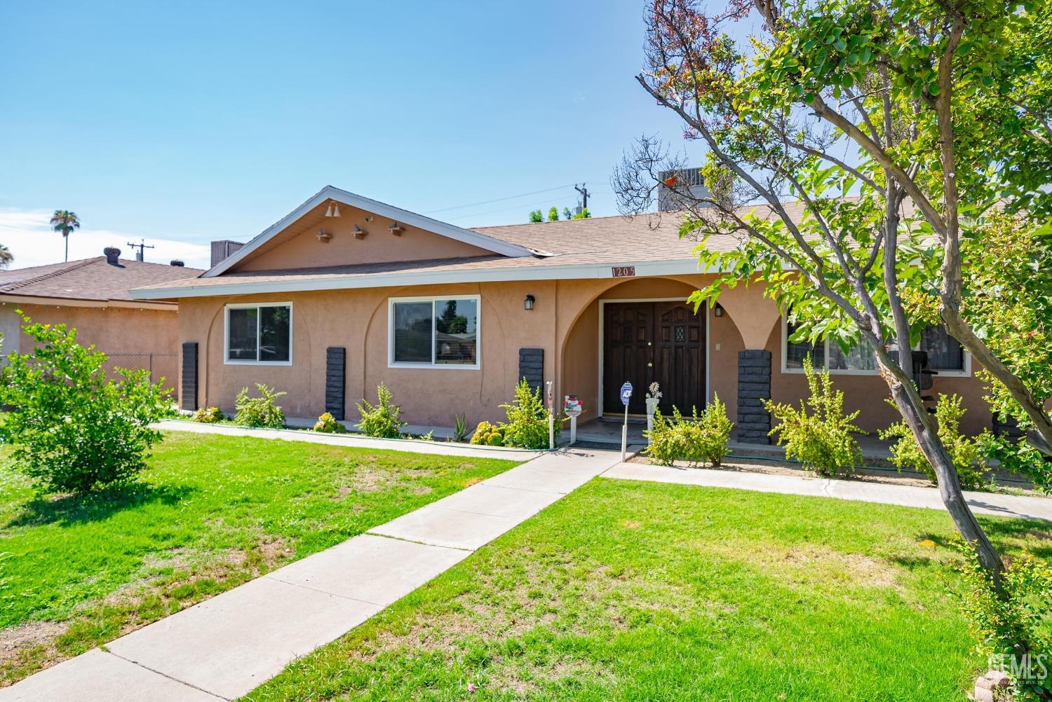 Undisclosed Address Bakersfield, CA 93307 - Photo 2 of 26 a front view of a house with a yard and porch