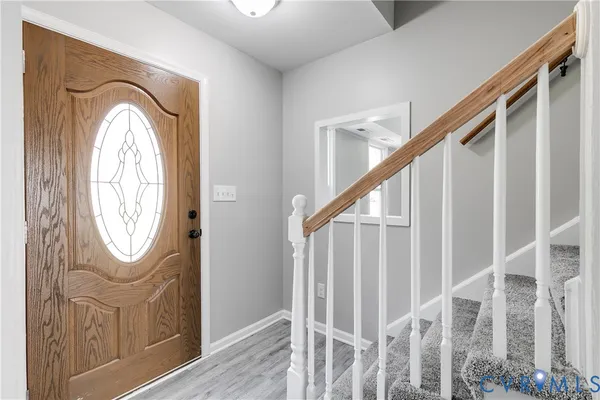 a view of a hallway with wooden floor and entryway