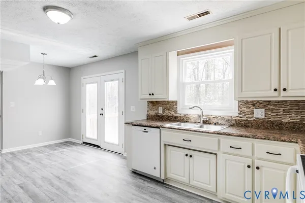 a kitchen with granite countertop white cabinets and a window