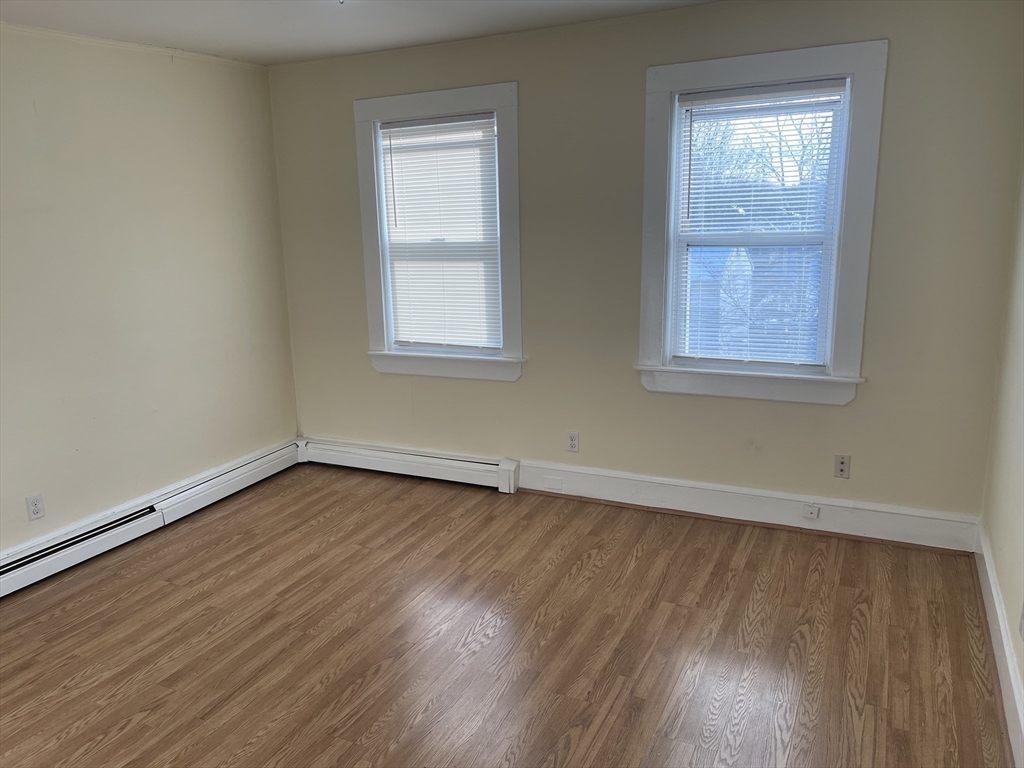 5 Albemarle Street, Unit 3 Boston, MA 02136 - Photo 2 of 8 an empty room with wooden floor and windows