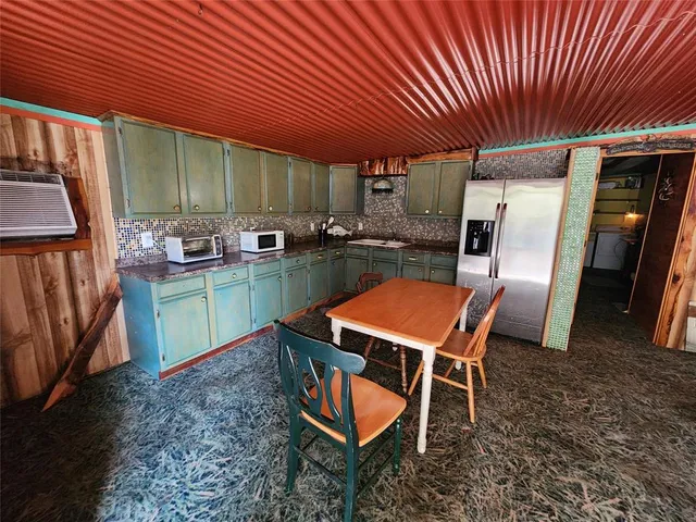 a room with chairs and kitchen view