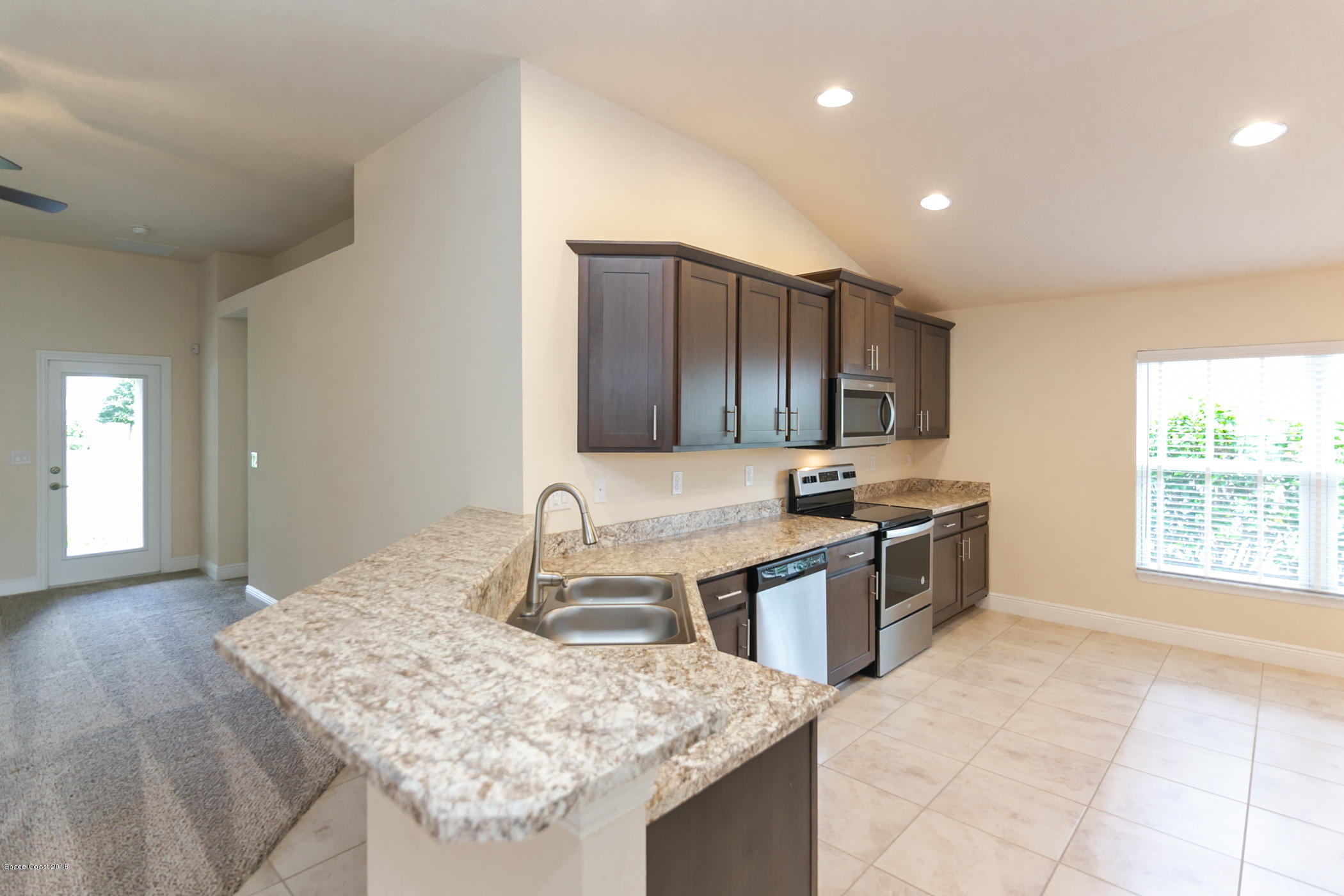 1168 Hathaway Road Southwest Palm Bay, FL 32908 - Photo 4 of 9 a kitchen with stainless steel appliances granite countertop a sink stove and cabinets
