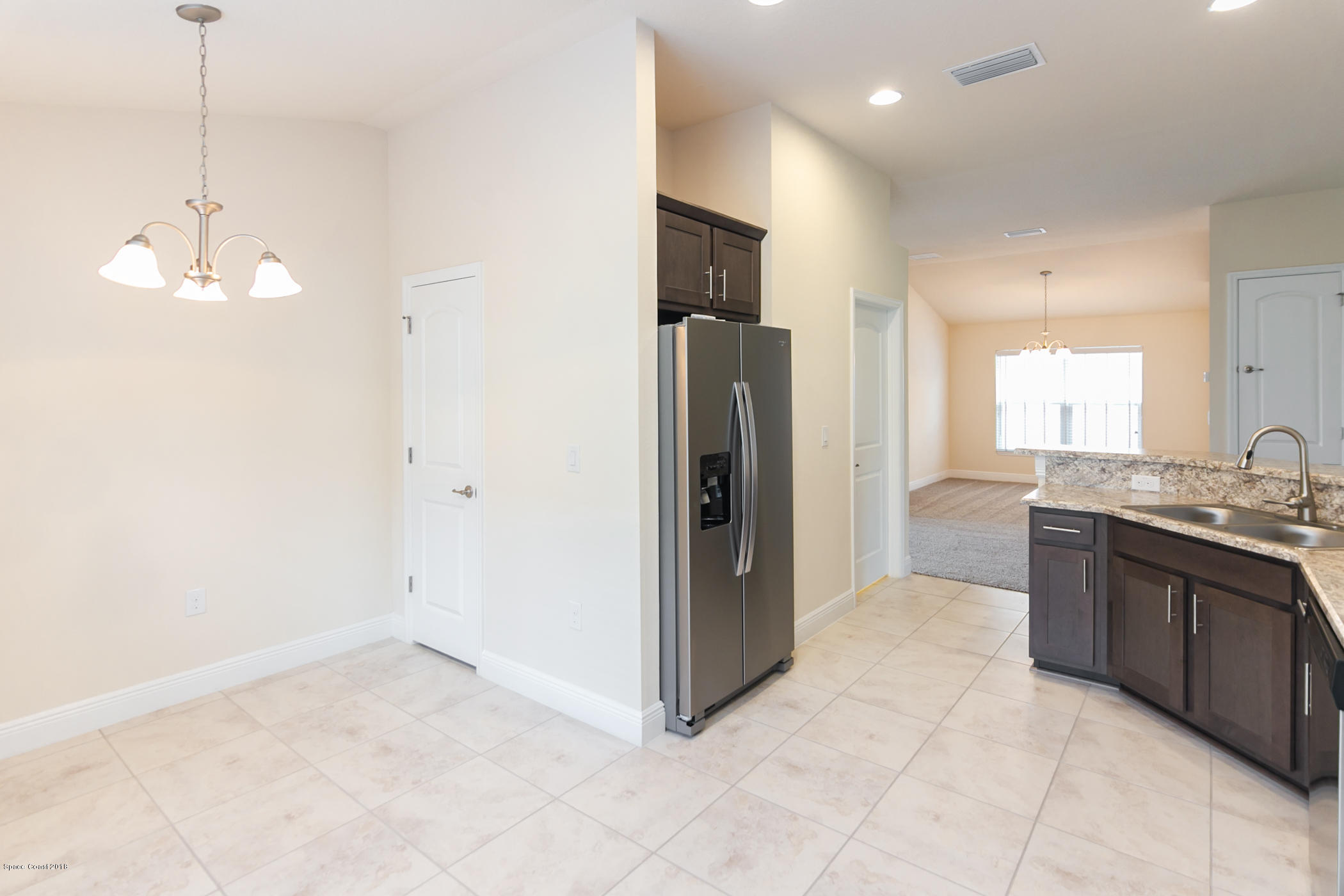 1168 Hathaway Road Southwest Palm Bay, FL 32908 - Photo 6 of 9 a view of a kitchen with a sink and a refrigerator