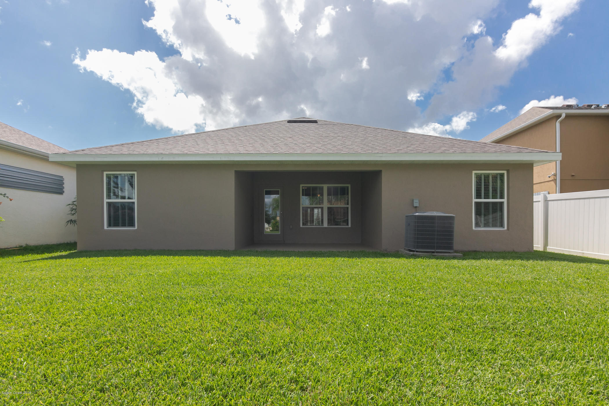 1168 Hathaway Road Southwest Palm Bay, FL 32908 - Photo 9 of 9 a backyard of a house with lots of green space and outdoor kitchen