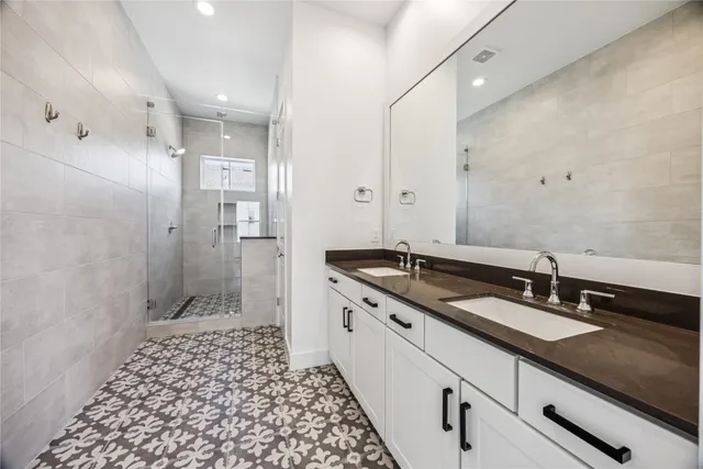 a spacious bathroom with a granite countertop sink a toilet a mirror and shower