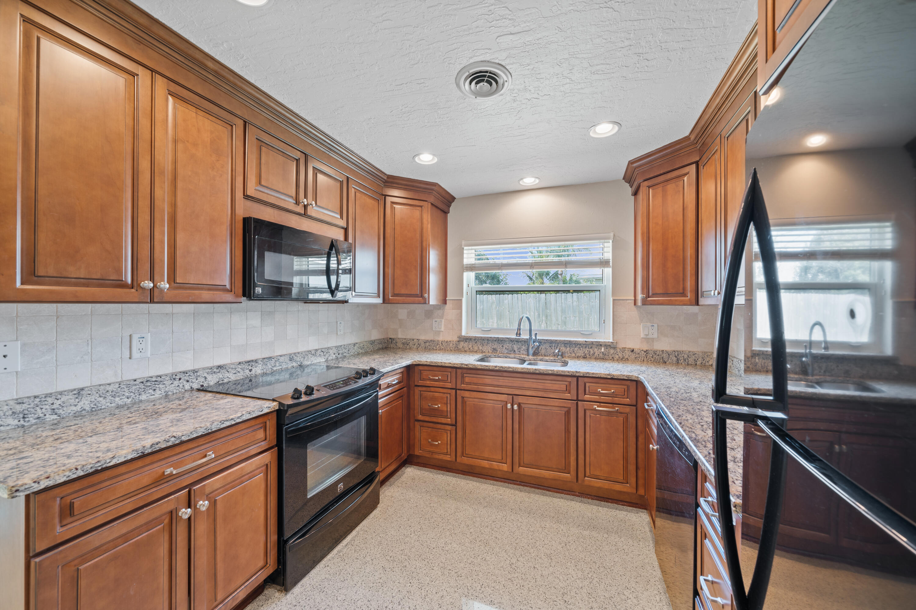 415 Rosedale Drive Satellite Beach, FL 32937 - Photo 21 of 52 a kitchen with stainless steel appliances granite countertop a sink stove and cabinets