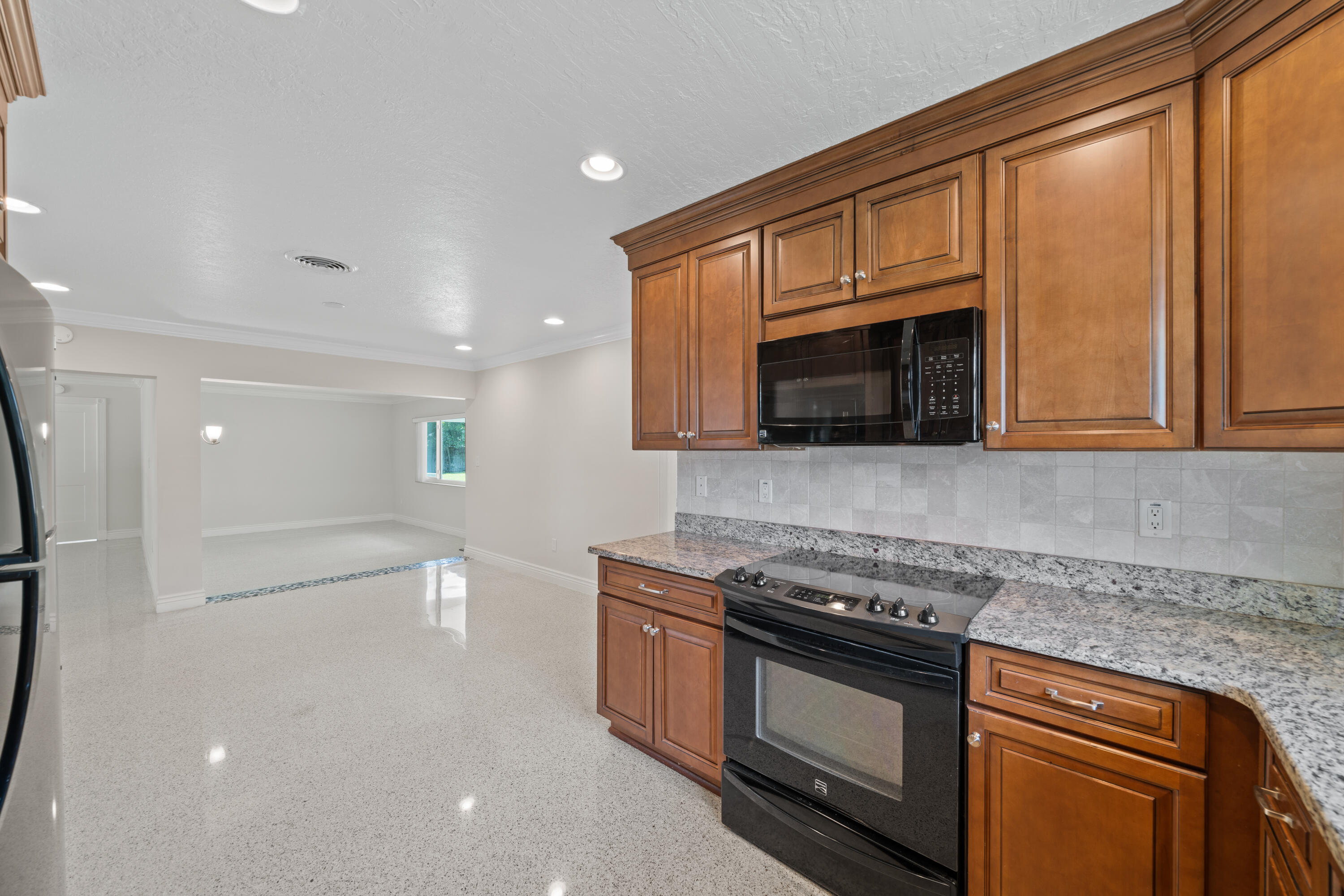 415 Rosedale Drive Satellite Beach, FL 32937 - Photo 23 of 52 a kitchen with stainless steel appliances granite countertop a stove and a microwave