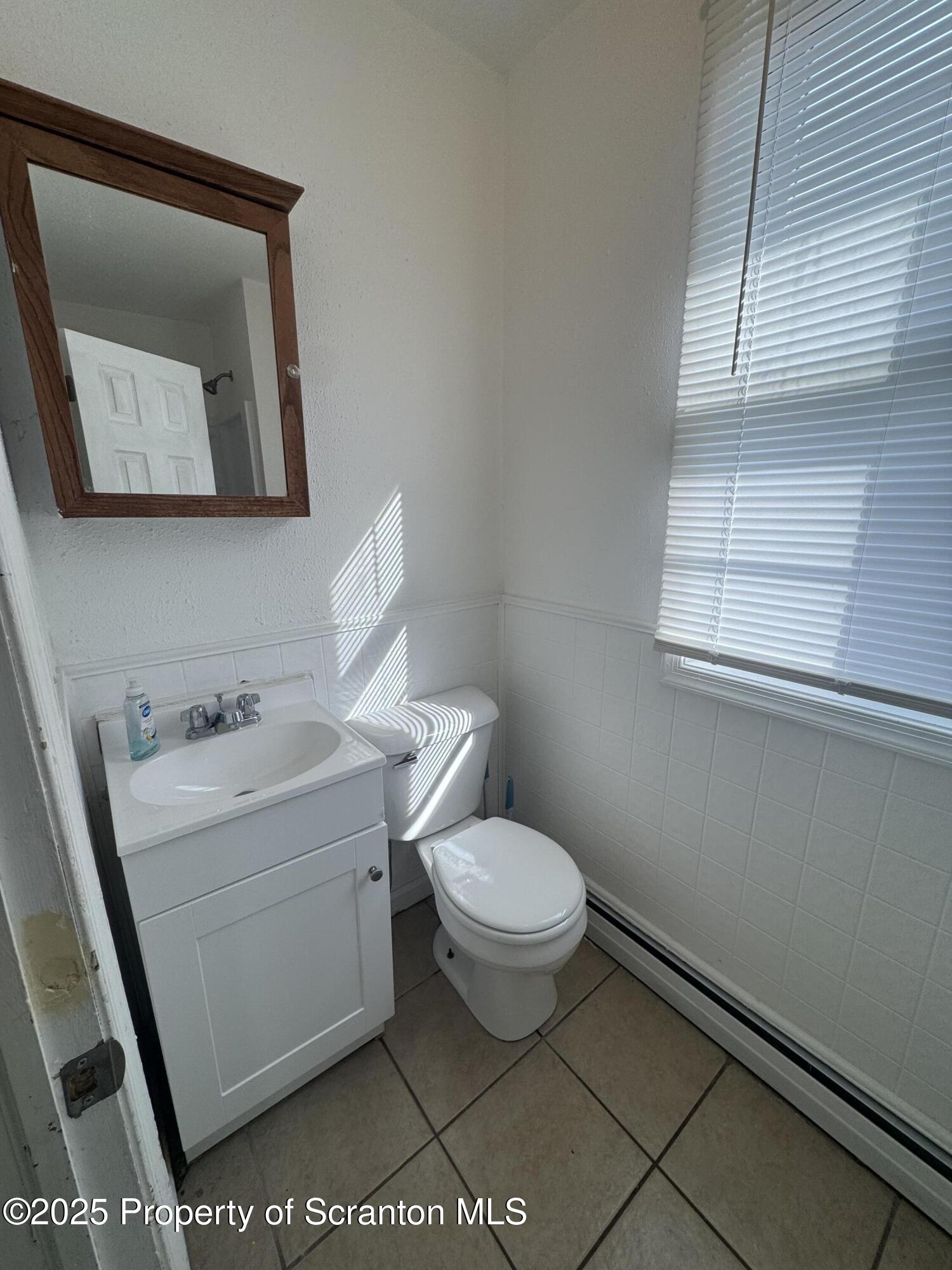 1135 Lloyd Street, Unit 2 Scranton, PA 18508 - Photo 14 of 21 a bathroom with a toilet a sink and mirror