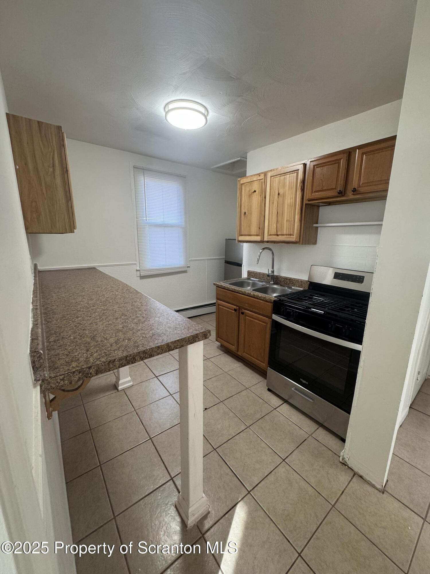 1135 Lloyd Street, Unit 2 Scranton, PA 18508 - Photo 18 of 21 a kitchen with stainless steel appliances granite countertop a sink and cabinets