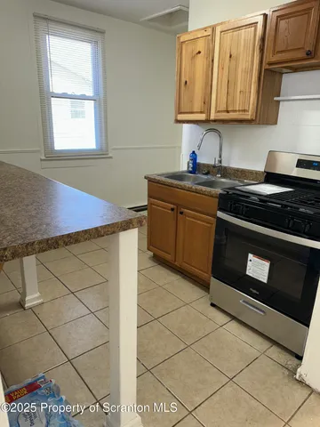 a kitchen with stainless steel appliances granite countertop a sink and a stove