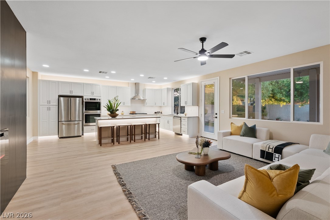 1662 Ravanusa Drive Henderson, NV 89052 - Photo 59 of 74 An open-concept living space integrates a chef's kitchen and comfortable seating, all illuminated by recessed lighting.