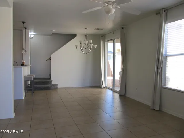 a view of a hallway with windows and chandelier