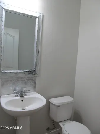a bathroom with a toilet a sink and a mirror