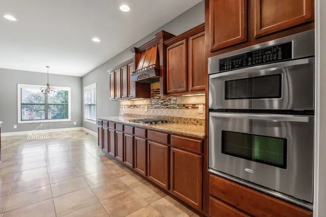 a kitchen with stainless steel appliances kitchen island granite countertop a stove a microwave and a sink