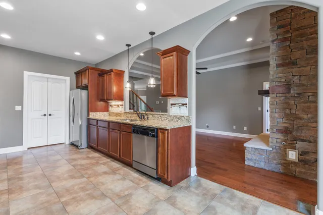 a kitchen with stainless steel appliances granite countertop a sink and a refrigerator