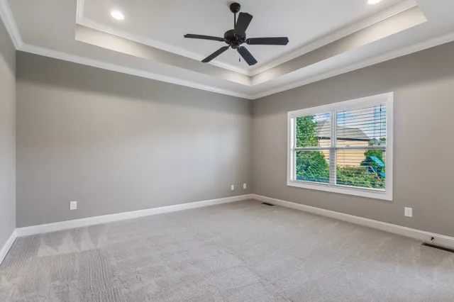 an empty room with a window and a fan