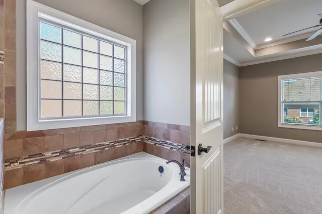 a bath tub sitting in a bathroom next to a window
