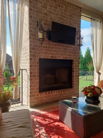 a living room with furniture a flat screen tv and a fireplace