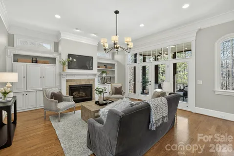 a living room with furniture a fireplace and a chandelier