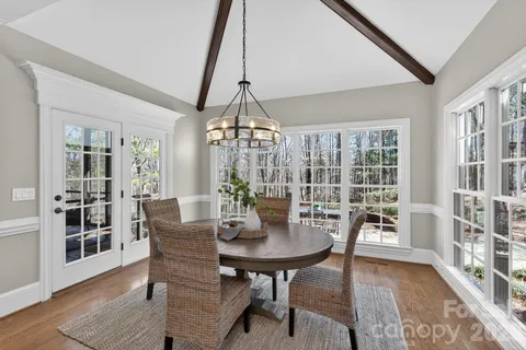 a vase of flowers sitting on a table with window