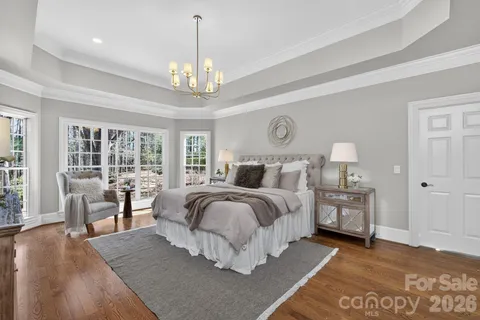 a bedroom with a large bed and a chandelier
