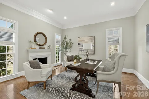 a living room with furniture a fireplace a rug and a window