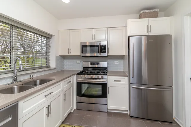a kitchen with refrigerator a sink and a microwave