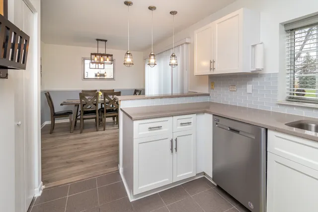 a kitchen with white cabinets and sink
