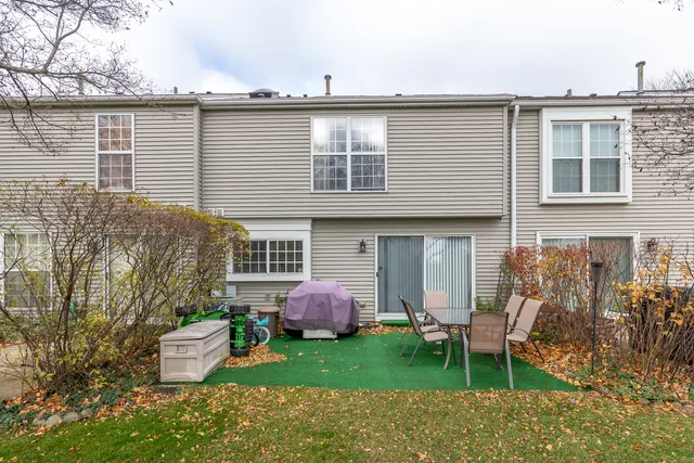a view of a house with a backyard and chairs