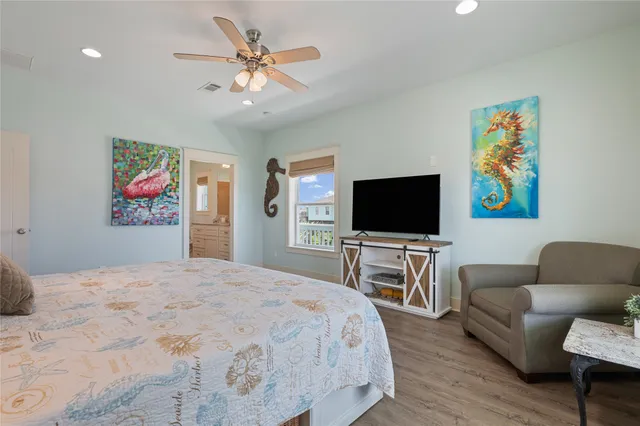 a bedroom with a bed a couch and a flat screen tv