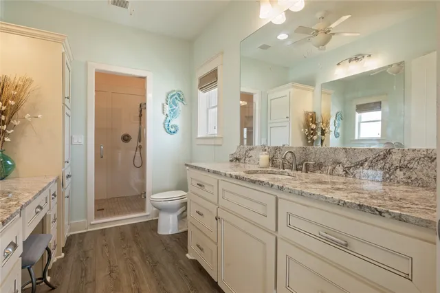 a bathroom with a granite countertop sink toilet a large mirror a vanity and shower