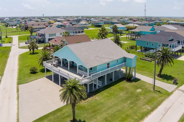 a aerial view of a house with a big yard and palm trees