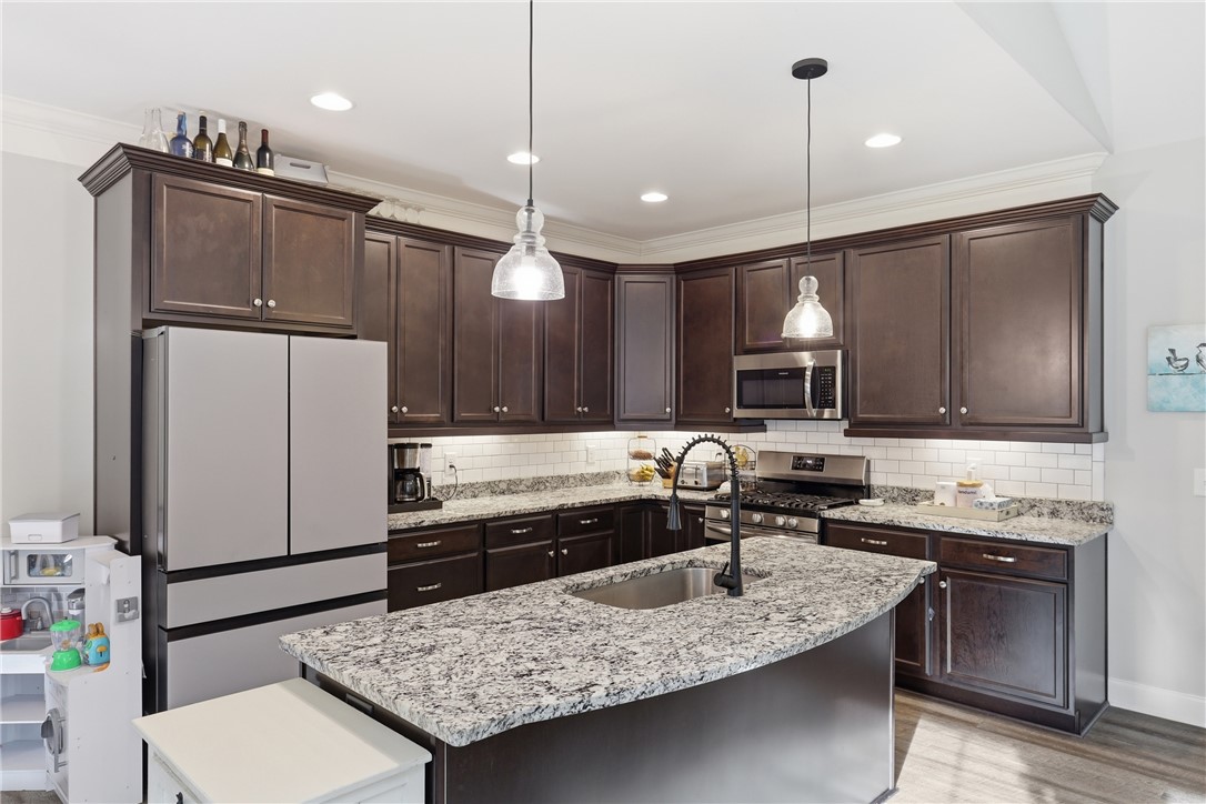 127 West Stewart Street Pelzer, SC 29669 - Photo 6 of 23 This kitchen showcases ample cabinetry, modern appliances, and a practical island with a sink.